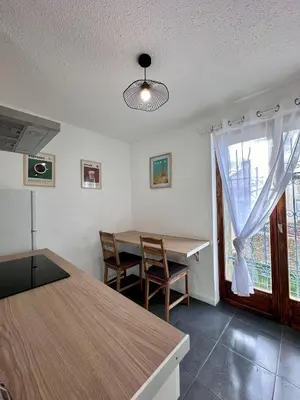 a dining room with a table and chairs and a window at Maison confortable - 5min de Carcassonne in Conques-sur-Orbiel