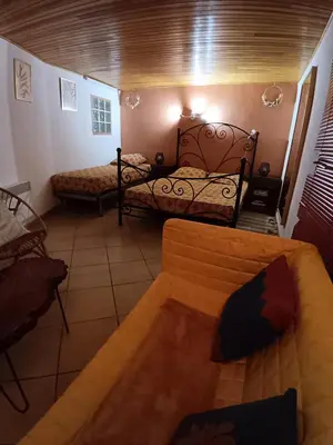 a living room with two beds and a couch at Chambre d'hôte Les maisons de Gaia in Tuchan