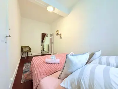 a bedroom with two beds and a pink bedspread at La Comtale in Carcassonne