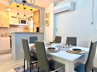 a dining room with a white table and chairs at La Comtale in Carcassonne