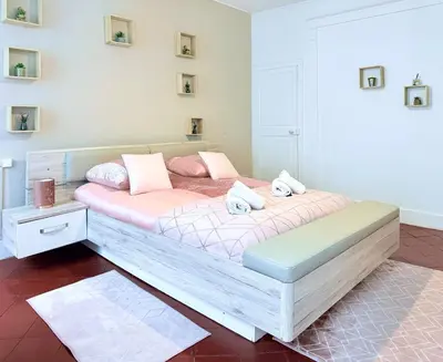 a bedroom with a large bed with pink pillows at La Comtale in Carcassonne
