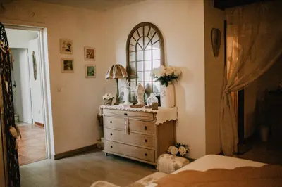 a bedroom with a dresser and a mirror at Chez Géraldine in Montels