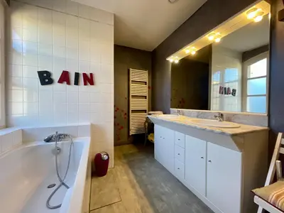 a bathroom with a tub and a sink and a bath tub at Côté Cité appartements - Parking privé - 100m Cité médiévale in Carcassonne