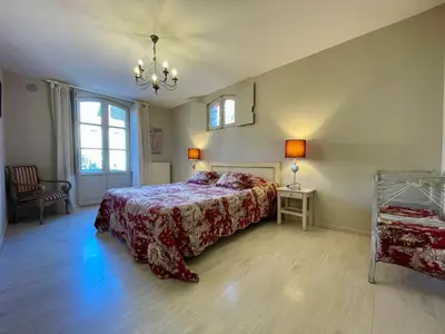 a bedroom with a bed and a chandelier at Côté Cité appartements - Parking privé - 100m Cité médiévale in Carcassonne
