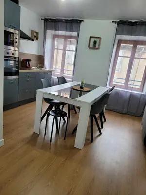 a white dining table and chairs in a kitchen at Charmant T3 avec terrasse in Carcassonne
