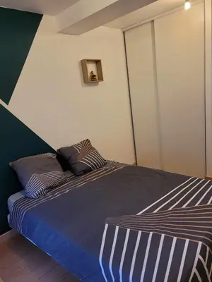 a bed with two pillows on it in a bedroom at Charmant T3 avec terrasse in Carcassonne