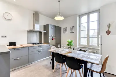 a kitchen and dining room with a table and chairs at Le Marty - wifi - central - climatison - parking gratuit in Carcassonne