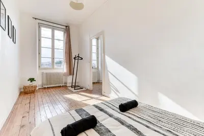 a white bedroom with a large bed in a room at Le Marty - wifi - central - climatison - parking gratuit in Carcassonne