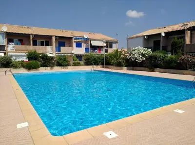 a large blue swimming pool in front of a building at Le Bleu du Sud in Gruissan