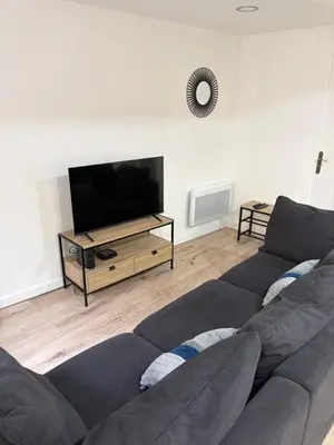 a living room with a couch and a flat screen tv at La Maison du Roi Arthur in Carcassonne