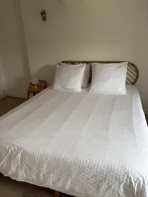 a large white bed with white sheets and pillows at La Maison du Roi Arthur in Carcassonne