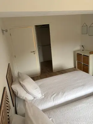 a white bedroom with a bed and a closet at La Maison du Roi Arthur in Carcassonne