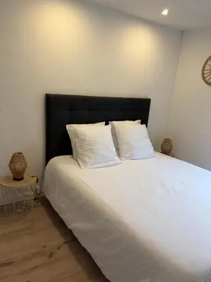 a bed with a black headboard and white pillows at La Maison du Roi Arthur in Carcassonne