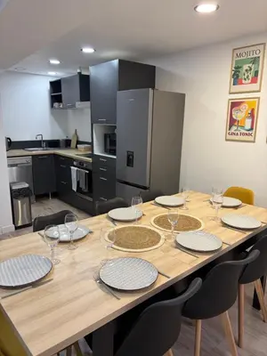 a dining room table with plates and wine glasses at La Maison du Roi Arthur in Carcassonne