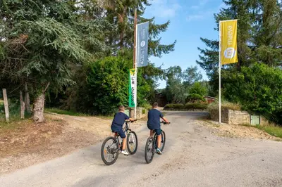 two boys riding bikes on a dirt road at Camping maeva Respire La Serre in Aigues-Vives