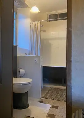 a bathroom with a white toilet and a shower at La Maison dans la forêt in Vabre