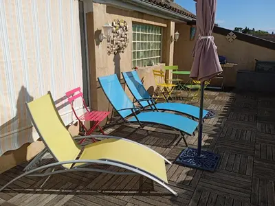 a group of chairs and an umbrella on a deck at Château Winery la Batisse le minervois in La Redorte