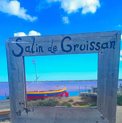 a wooden sign with a boat on the beach at Studio Oasis Narbonne Terrasse & Calme in Narbonne