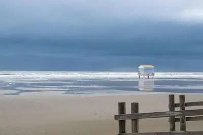 a beach with a life guard chair and the ocean at L'olivier de Nonna in Gruissan