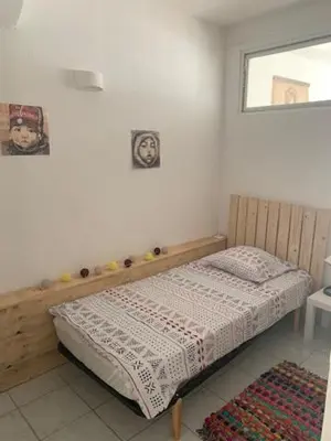 a bedroom with a bed in the corner of a room at L'olivier de Nonna in Gruissan