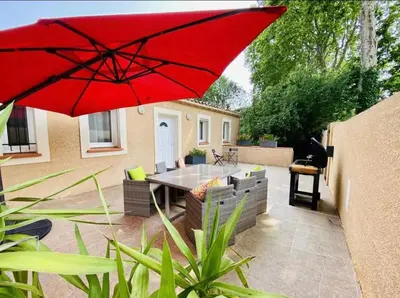 a red umbrella sitting on top of a patio at Villa Tamaris in Carcassonne