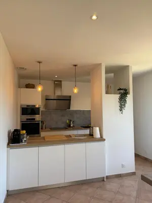 a kitchen with white cabinets and a counter top at Villa Tamaris in Carcassonne