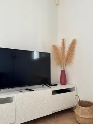 a white entertainment center with a large screen television at Villa Tamaris in Carcassonne