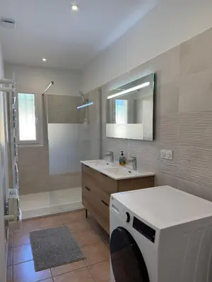 a bathroom with a sink and a washing machine at Villa Tamaris in Carcassonne