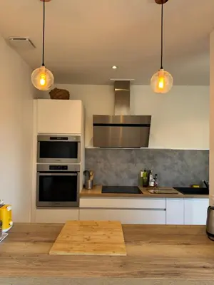 a kitchen with white cabinets and a stove top oven at Villa Tamaris in Carcassonne