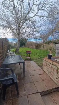 a patio with a table and a bench in a yard at Charmante Maison de Village T3 Rénovée et son Jardin in Revel