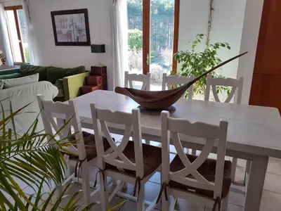 a dining room table with white chairs and a bowl on it at Villa les terre rouges avec piscine dans l ' Aude in Arques