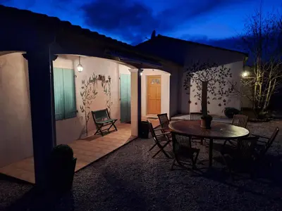 a patio with a table and chairs at night at Villa les terre rouges avec piscine dans l ' Aude in Arques