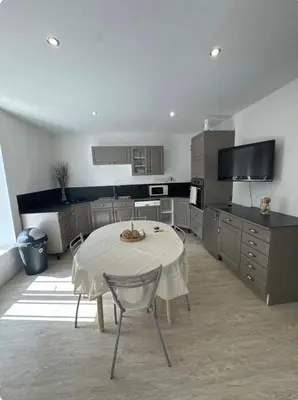 a kitchen with a white table and a kitchen with at Appartement T3 in Marseillette