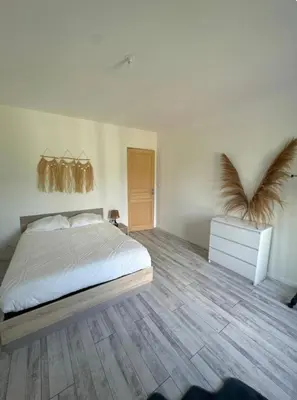 a bedroom with a bed and a wooden floor at Appartement T3 in Marseillette
