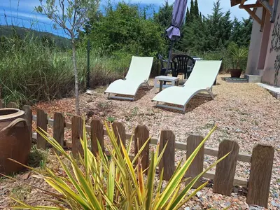 three white chairs in a backyard with a fence at Studio 