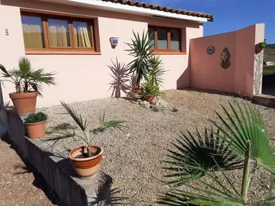 a house with a bunch of plants in front of it at Studio 