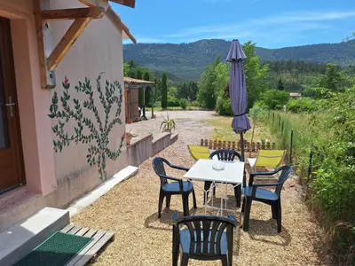 a patio with a table and chairs and an umbrella at Studio 