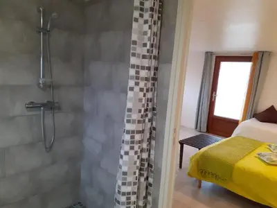 a bathroom with a shower and a bed in a room at Studio 
