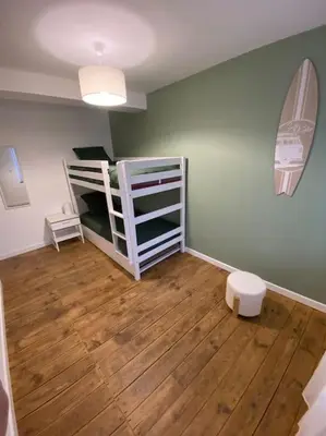 a room with two bunk beds and a wooden floor at Le gîte du bonheur in Dalou