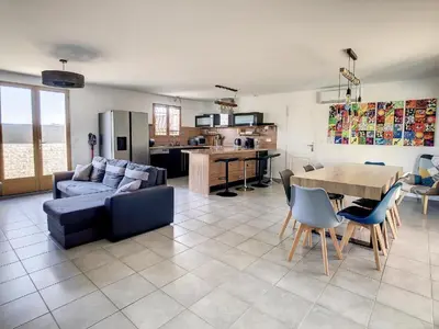 a living room with a couch and a table with chairs at La Cigotà - Villa with swimming pool for 8 people in Pouzols-Minervois