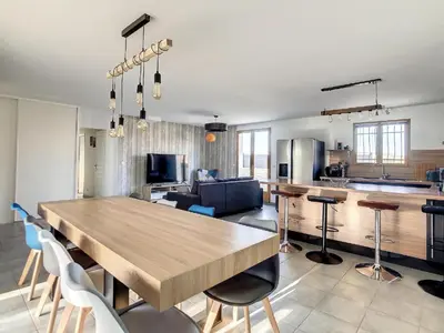 a kitchen and living room with a wooden table and chairs at La Cigotà - Villa with swimming pool for 8 people in Pouzols-Minervois