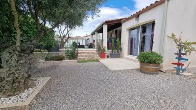 a house with a tree next to a building at La Cigotà - Villa with swimming pool for 8 people in Pouzols-Minervois