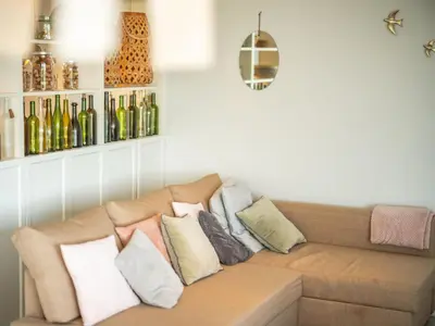 a couch in a living room with bottles on the wall at Évasion champêtre à Horizon P'y - Piscine in Puéchoursi