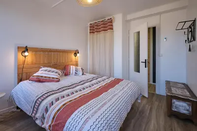 a bedroom with a large bed with a wooden headboard at Magnifique*T4*centre ville*WIFI*Billard*Netflix* in Limoux