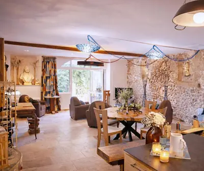 a living room with a table and a couch at Le1693 - Charme & confort 4 étoiles - Jacuzzi in Limoux