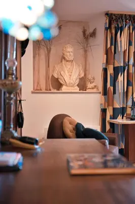 a person laying on a couch in a living room with a statue at Le1693 - Charme & confort 4 étoiles - Jacuzzi in Limoux