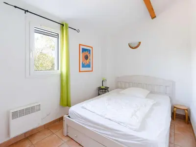 a bedroom with a white bed and a window at Pavillon climatisé 4 pièces avec WIFI, proche plage, terrasse, barbecue, park. privatif, animaux admis - FR-1-409-249 in Gruissan