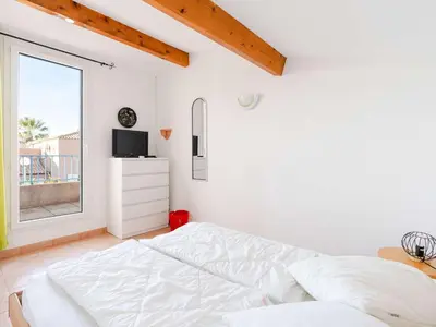 a white bedroom with a bed and a window at Pavillon climatisé 4 pièces avec WIFI, proche plage, terrasse, barbecue, park. privatif, animaux admis - FR-1-409-249 in Gruissan