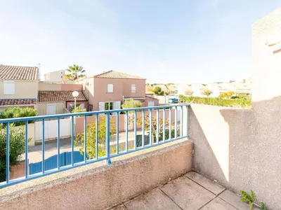 a balcony with a blue railing and condos at Pavillon climatisé 4 pièces avec WIFI, proche plage, terrasse, barbecue, park. privatif, animaux admis - FR-1-409-249 in Gruissan