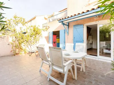 a white table and chairs on a patio at Pavillon climatisé 4 pièces avec WIFI, proche plage, terrasse, barbecue, park. privatif, animaux admis - FR-1-409-249 in Gruissan
